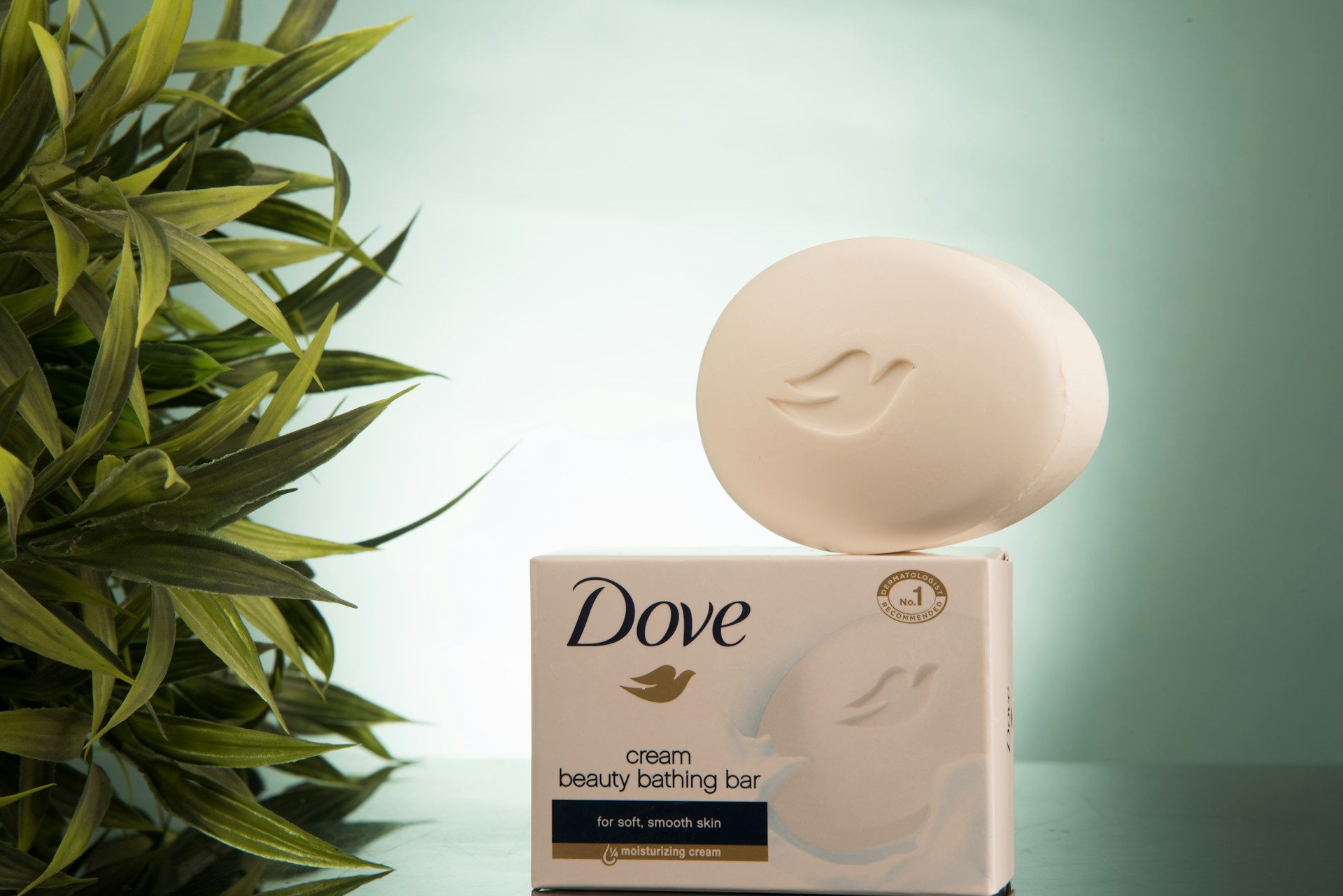 A photo-style image of Dove beauty bar soap displayed in a clean bathroom setting, representing gentle cleansing for sensitive scalp and skin. The image visually supports an article explaining that Dove soap may help reduce scalp irritation but does not treat or prevent hair loss.