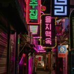 Neon signs in a narrow Korean alley at night, showcasing local restaurants and nightlife that reflect South Korea’s loconomy marketing and local culture.