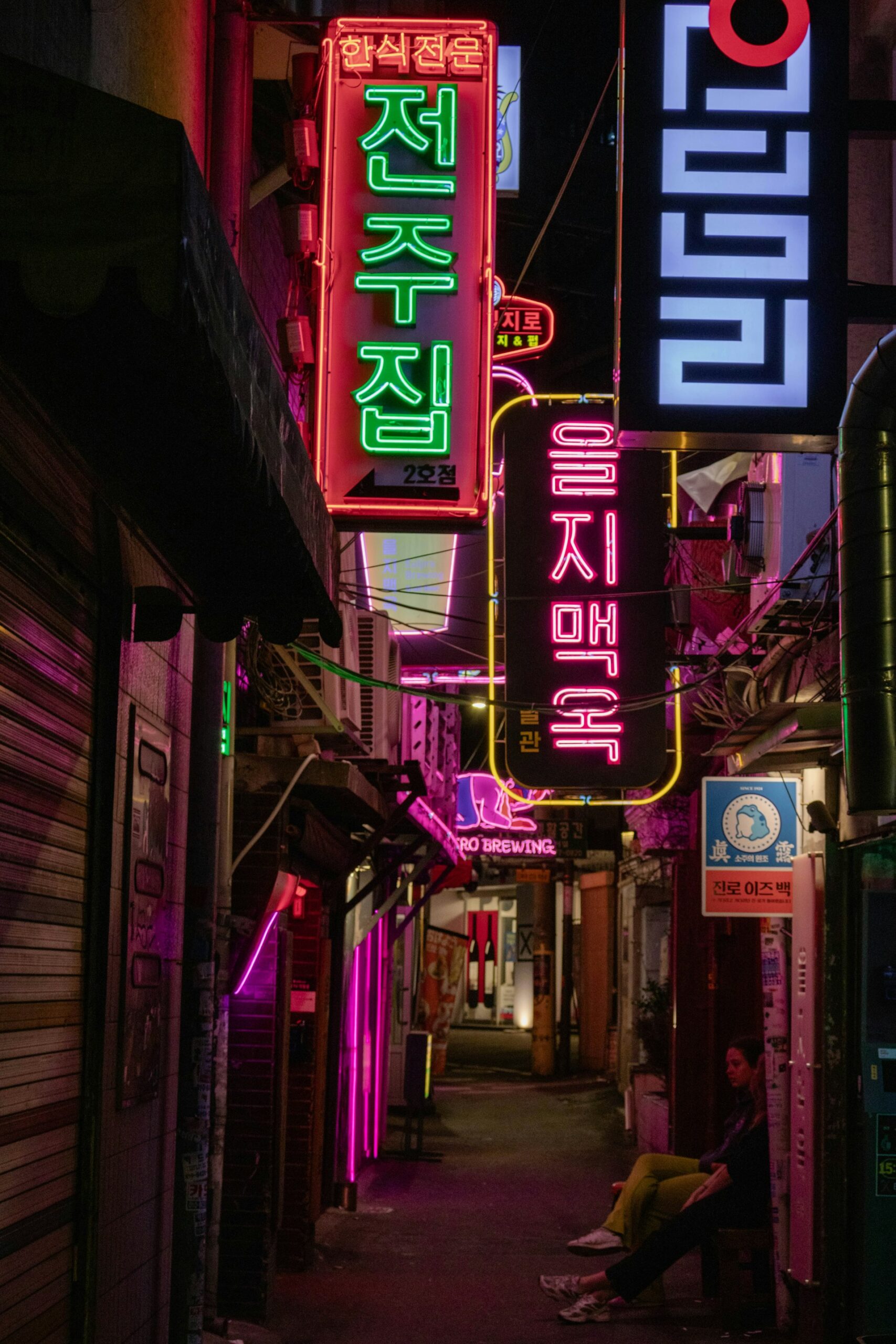Neon signs in a narrow Korean alley at night, showcasing local restaurants and nightlife that reflect South Korea’s loconomy marketing and local culture.