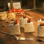 Korean-style strawberry cream cakes arranged on a wooden bakery display, showcasing premium desserts with fresh fruit toppings.