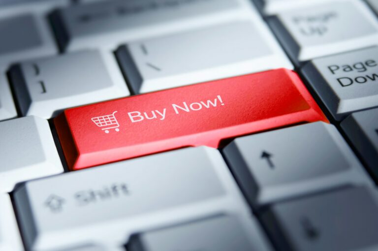 Close-up of a computer keyboard with a red ‘Buy Now’ key, symbolizing online purchasing and the growth of digital commerce and resale markets.